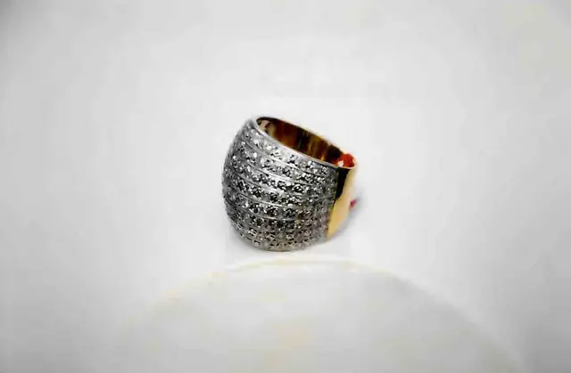 Um ANEL, pesando 14,7 gramas, em ouro 18 k, oitenta e sete BRILHANTES