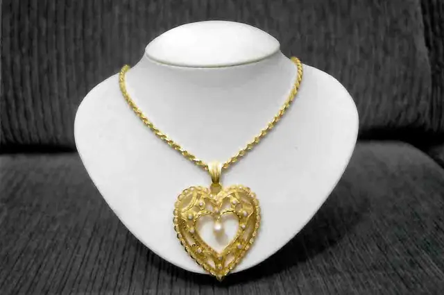 Um COLAR, pesando 66,60 gramas, em ouro 18 k, com quarenta e oito BRILHANTES e uma PÉROLA