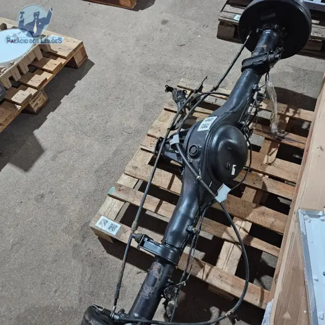 01 conjunto de eixo diferencial automotivo, com tambores de freio, cabos e tubulações.