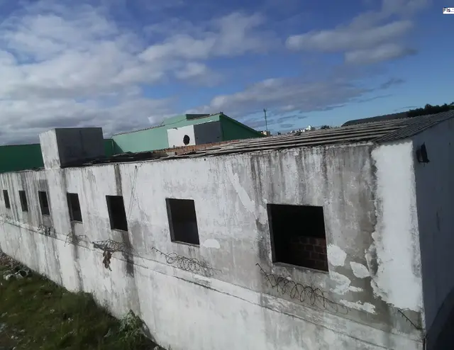 Um terreno com um prédio de alvenaria construído sobre ele
