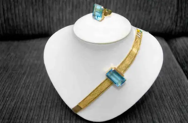 Uma PULSEIRA e um ANEL, pesando 70,4 gramas, em ouro 18 k, com dois TOPÁZIOS azuis