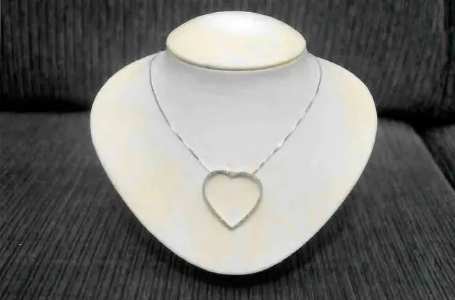 Um COLAR, pesando de 5,9 gramas, em ouro branco 18 k, com um CORAÇÃO, oitenta e seis BRILHANTES